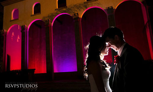 Couple Under Red Archway Lighting at The Bell Tower on 34th